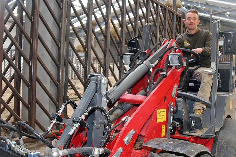 Tierpfleger sitzt auf einem Weidemann eHoftrac 1160