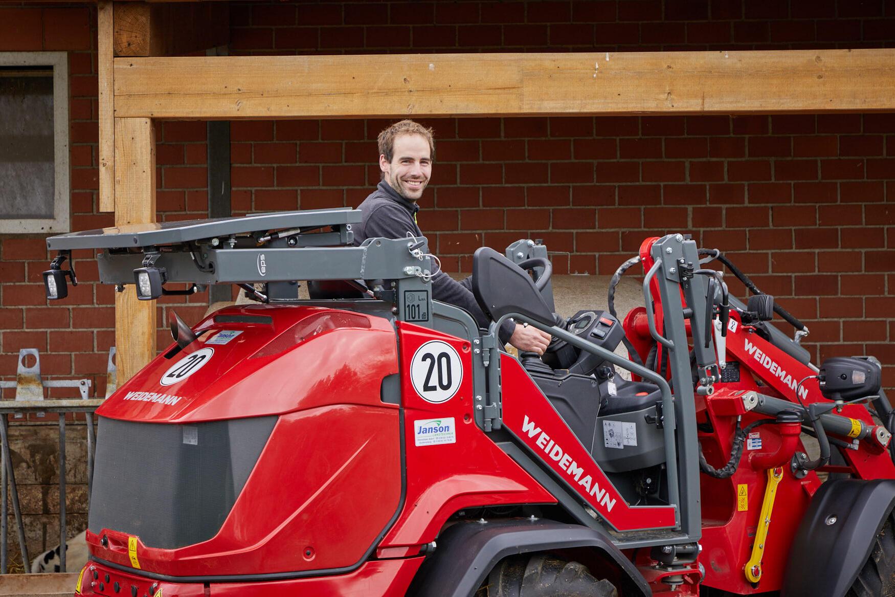 Person on Weidemann Hoftrac 1390 with folded down overhead guard