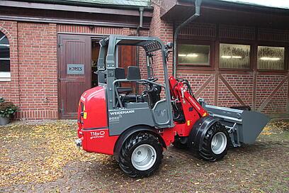 Weidemann Hoftrac 1160e steht draußen auf einem Pferdehof