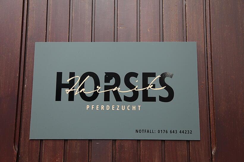 Schild an einer Wand mit der Aufschrift Horses Pferdezucht