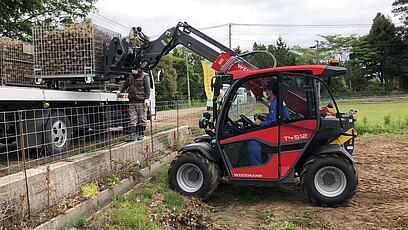 Weidemann Teleskoplader T4512 im Einsatz mit einer Palettengabel beim LKW beladen